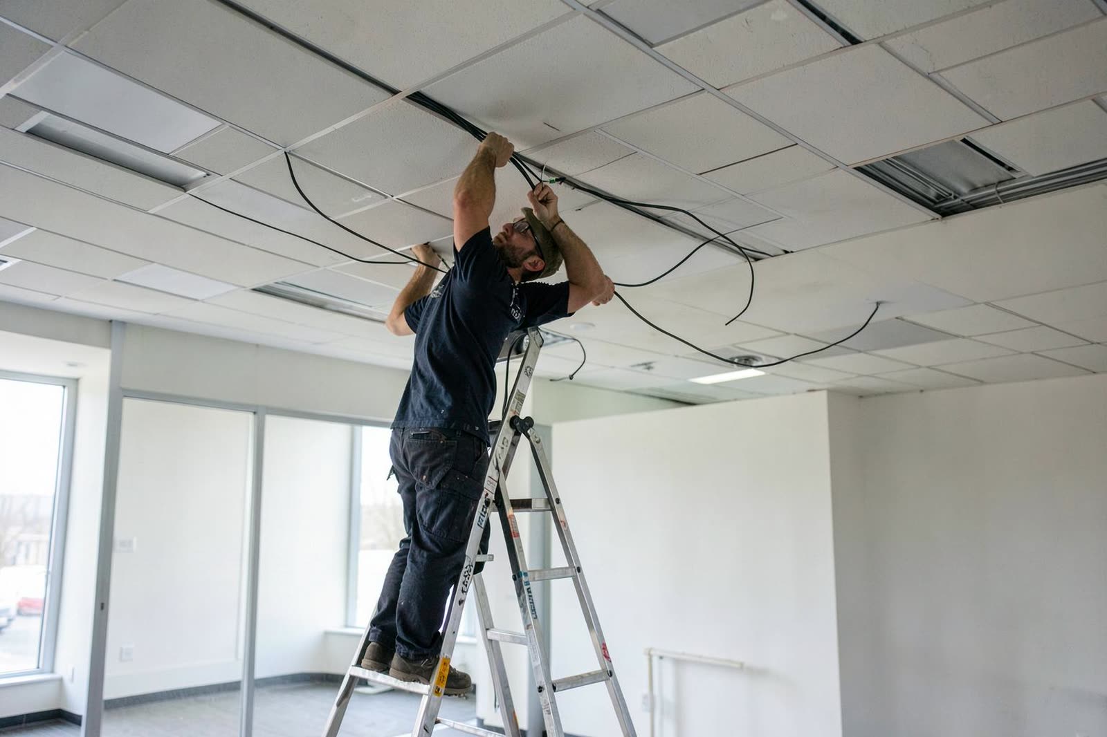 Técnicos trabajando en un edificio administrativo vacío durante un periodo de receso.