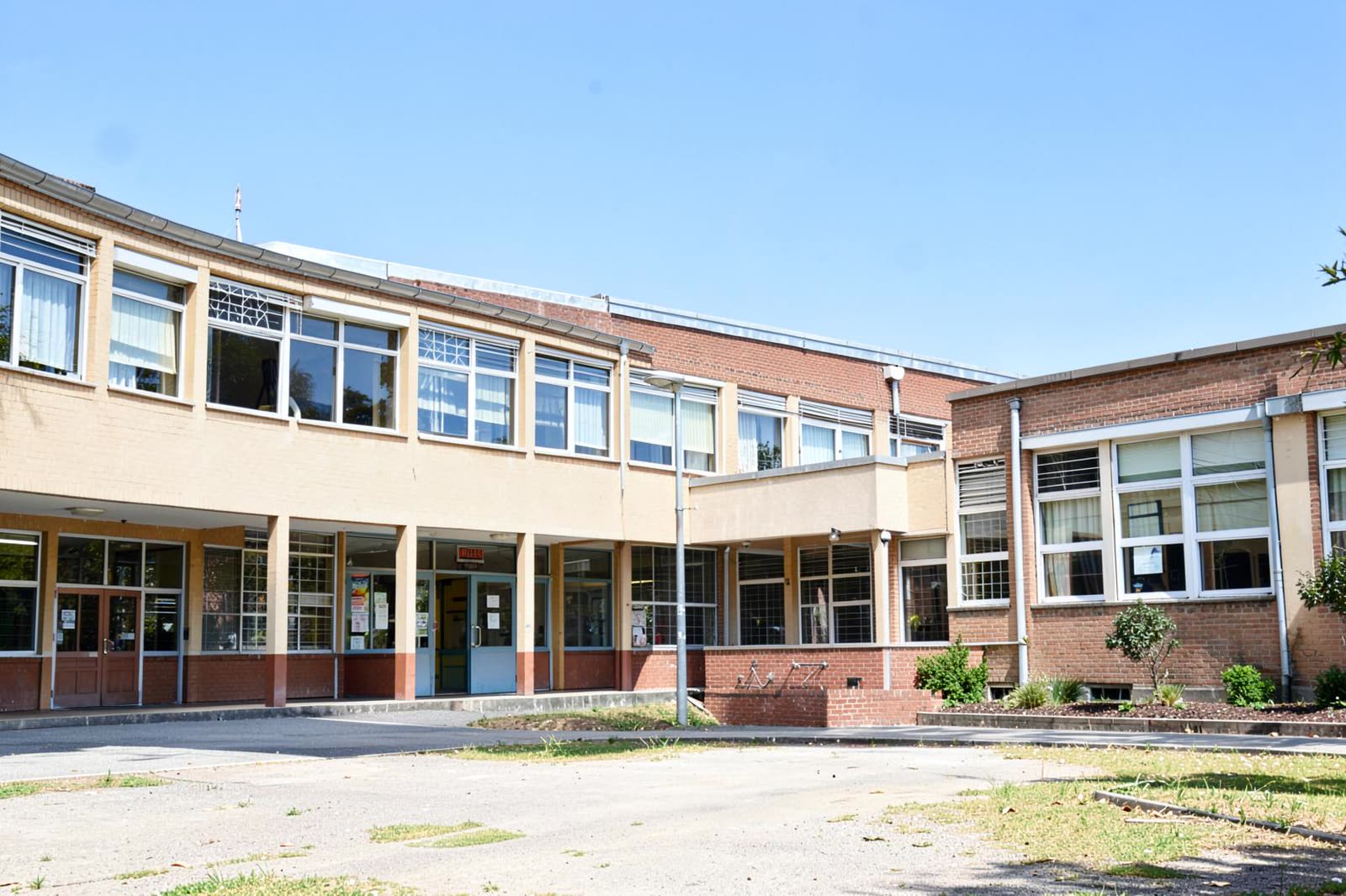 Edificio de un plantel educativo con áreas comunes en uso.